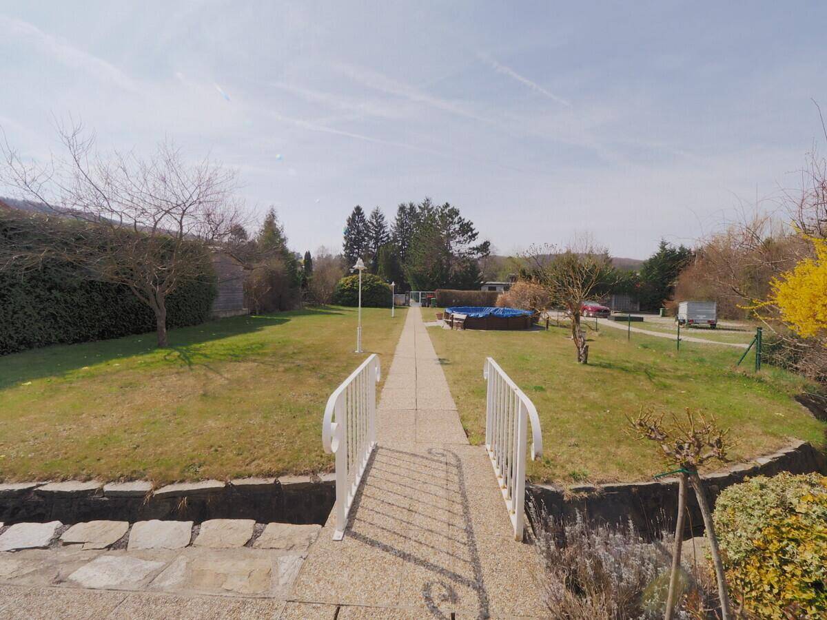 Blick vom Haus über den langen Gartenweg zum oberirdischen Poolbereich.