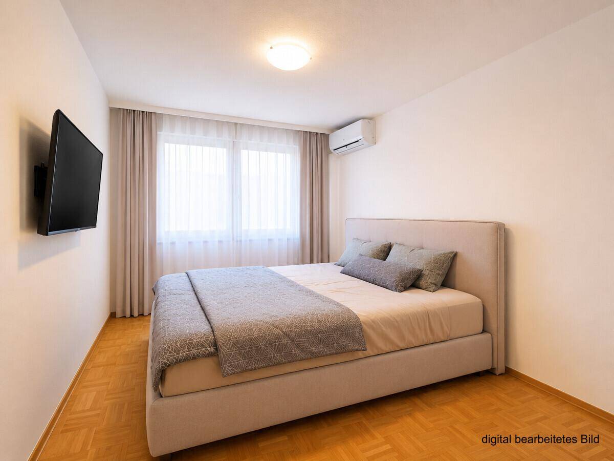 Komfortables Schlafzimmer mit Doppelbett, Parkettboden und Klimaanlage.