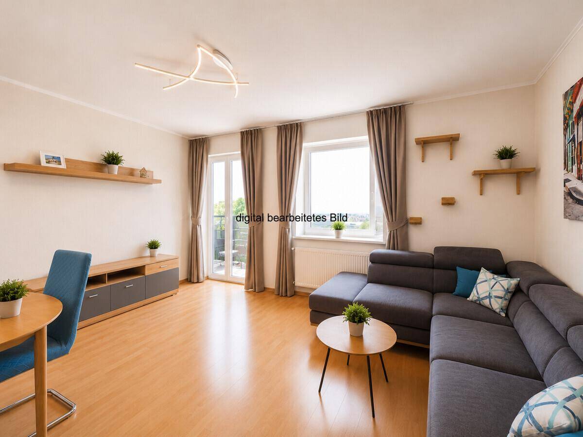 Gemütliches Wohnzimmer mit großem Ecksofa, Couchtisch und direktem Zugang zum Balkon.
