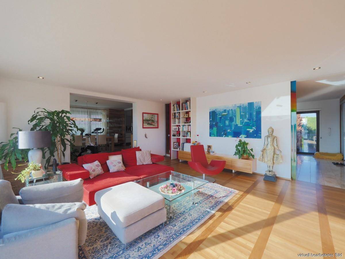Helles und geräumiges Wohnzimmer mit rotem Sofa, Holzboden und viel Tageslicht.