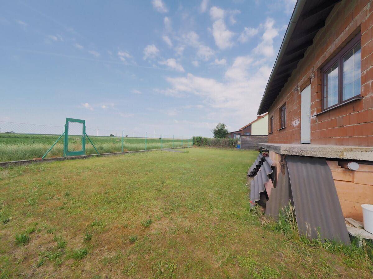 Weitläufiger Gartenbereich mit Blick auf die umliegenden Felder und die Natur.