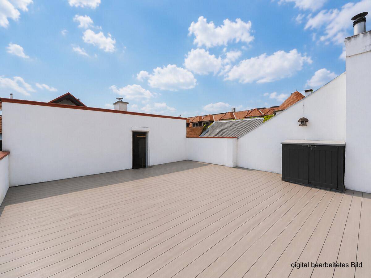 Große, leere Dachterrasse mit Holzboden und Zugang zu einem Abstellraum.