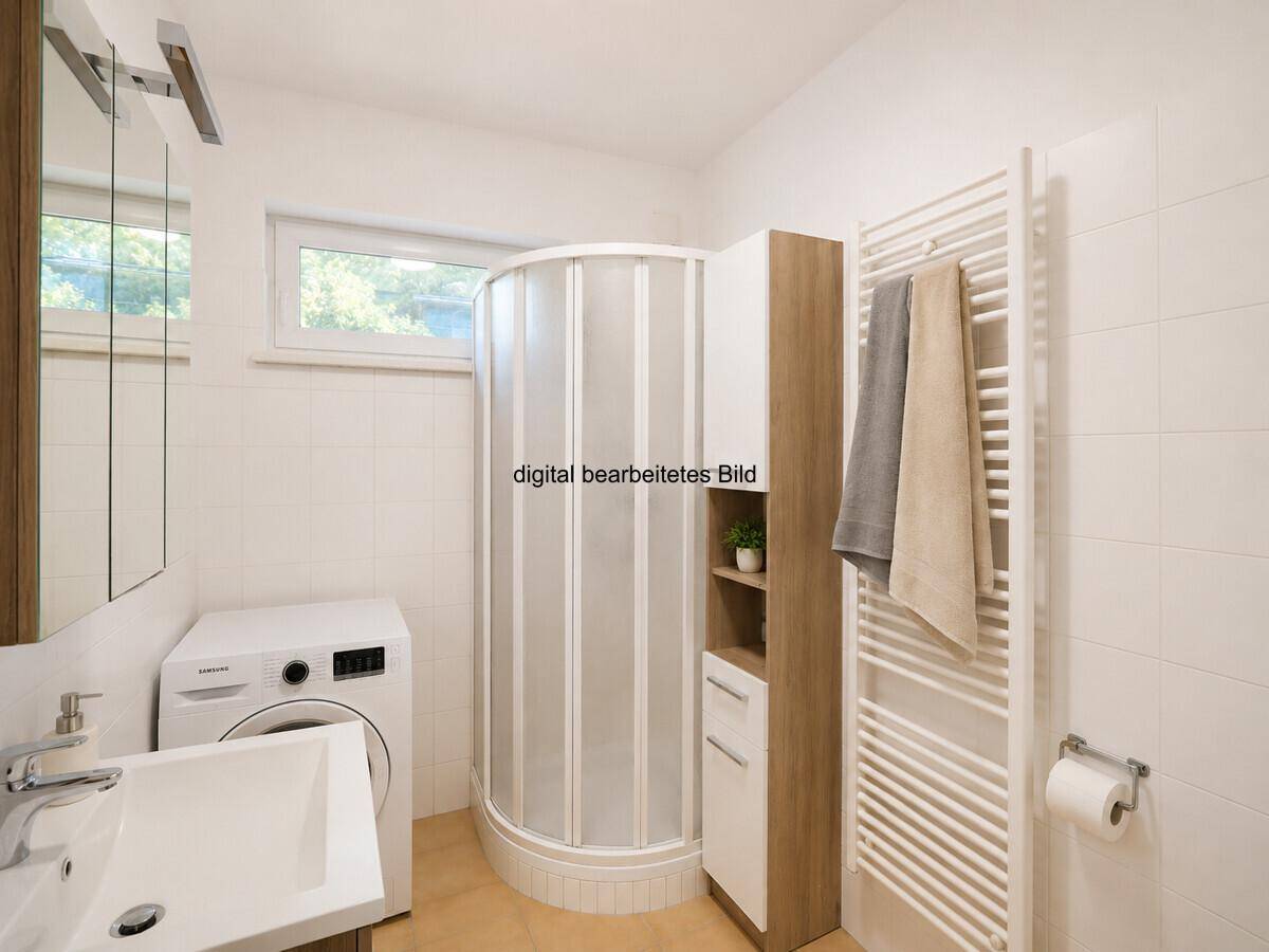 Funktionales Badezimmer mit Duschkabine, Waschmaschine, Waschbecken und Fenster.