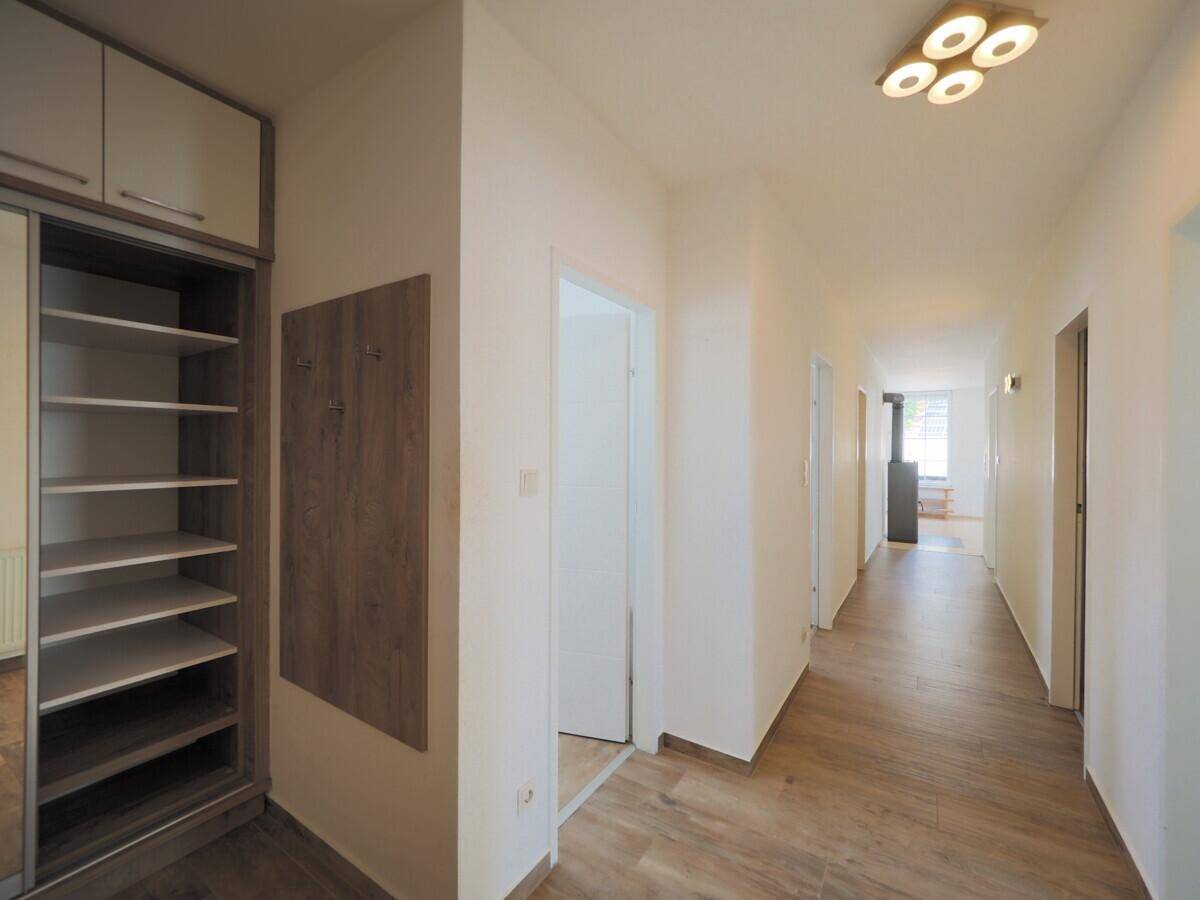 Langer Flur mit integriertem Stauraum, Garderobe und Laminatboden.