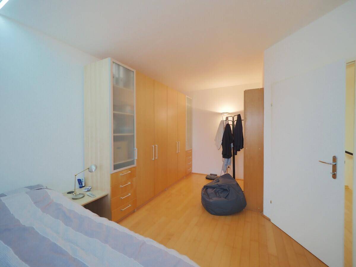 Schlafzimmer mit Holzboden und Einbauschränken, bietet viel Stauraum.