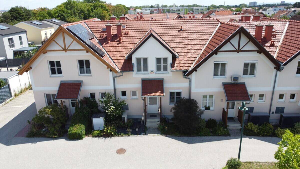 Reihenhäuser mit Satteldächern, Photovoltaikanlagen und gepflegten Vorgärten.