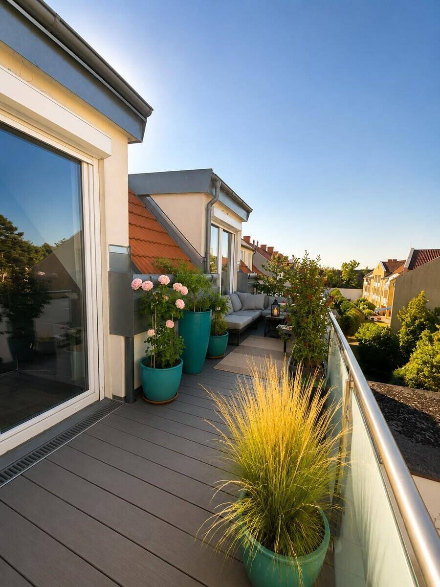 Sonniger Balkon mit modernen Outdoor-Möbeln und Pflanzen, bietet einen weiten Blick.