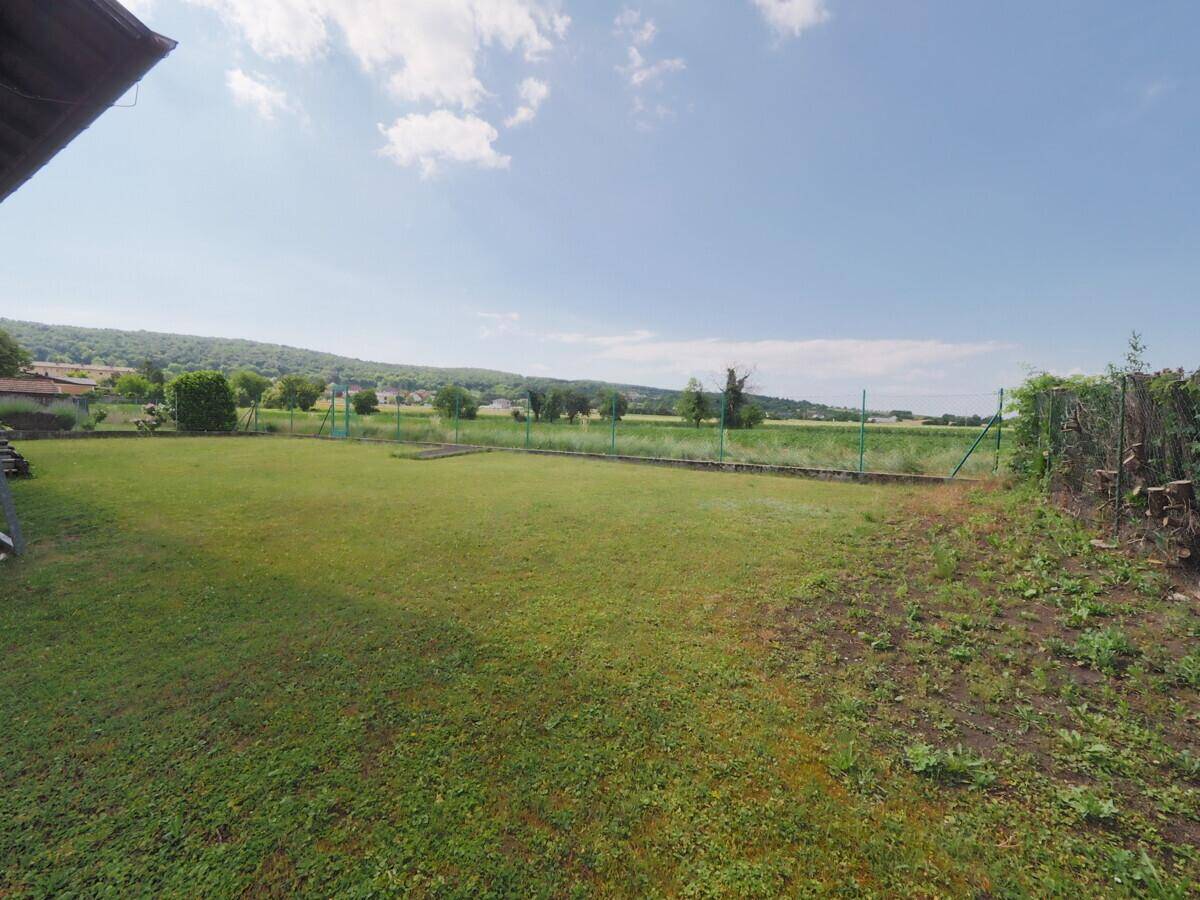 Garten mit weitem Blick über die grüne Landschaft und die sanften Hügel.