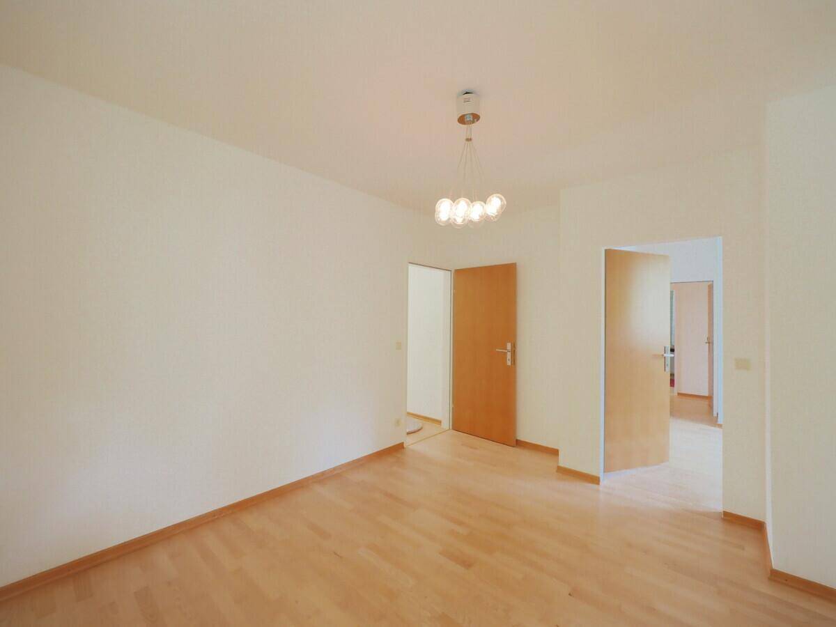 Leerer Raum mit Holzboden und mehreren Türen, bietet flexible Nutzungsmöglichkeiten.