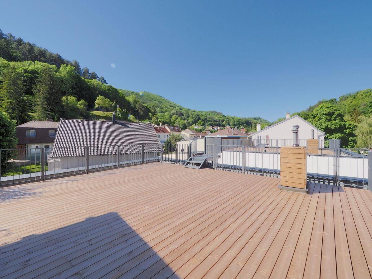 Weitläufige Dachterrasse mit Holzboden und Panoramablick auf die Hügellandschaft.