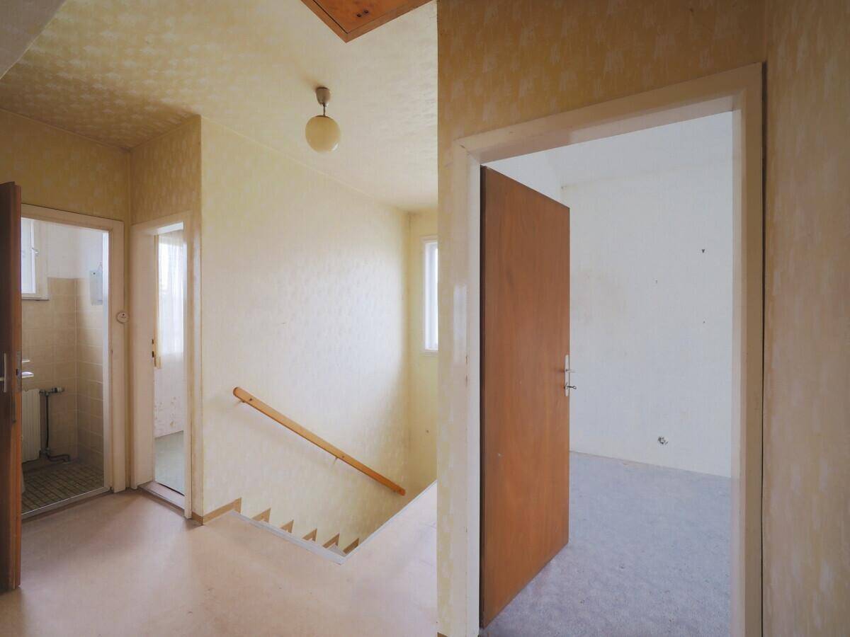Heller Flur mit Treppenaufgang und mehreren Türen, die zu den angrenzenden Räumen führen.