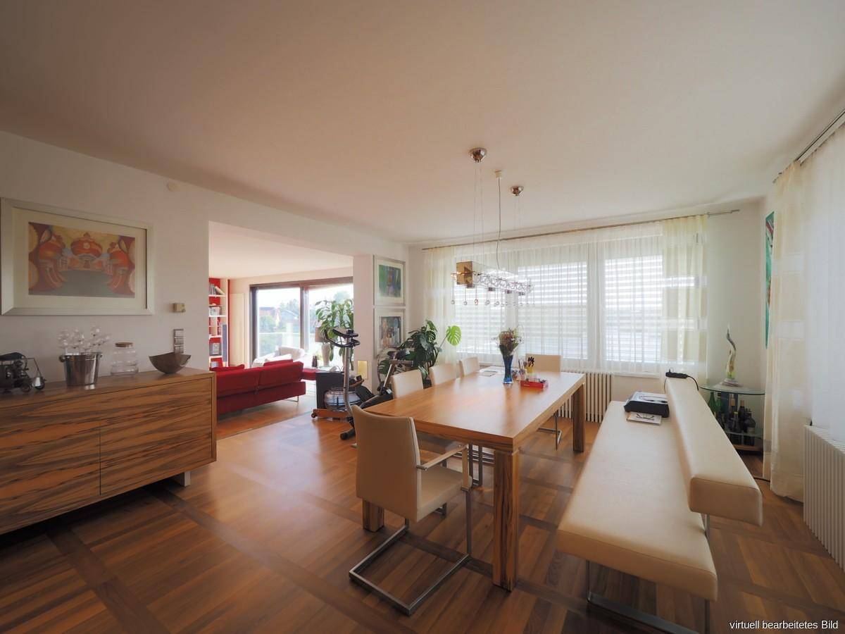 Heller Essbereich mit großem Holztisch, Parkettboden und Zugang zum angrenzenden Wohnzimmer.