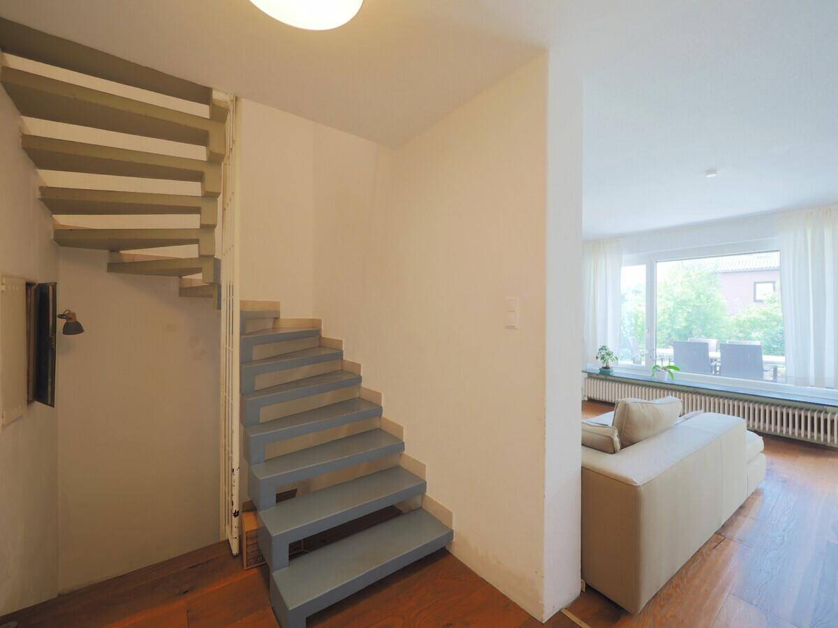 Moderne Treppe mit hellblauen Stufen, die in die obere Etage führt.