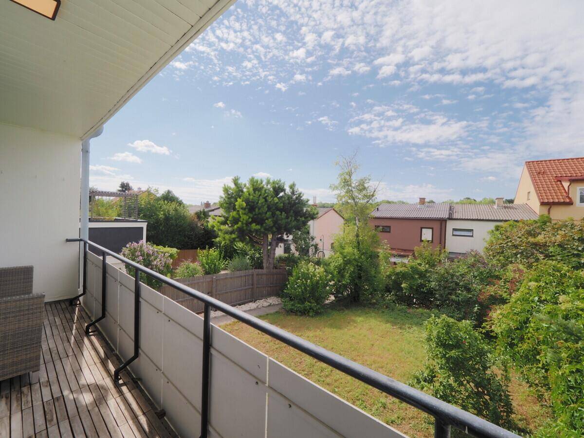 Balkon mit weitem Blick über den Garten und die umliegenden Häuser.