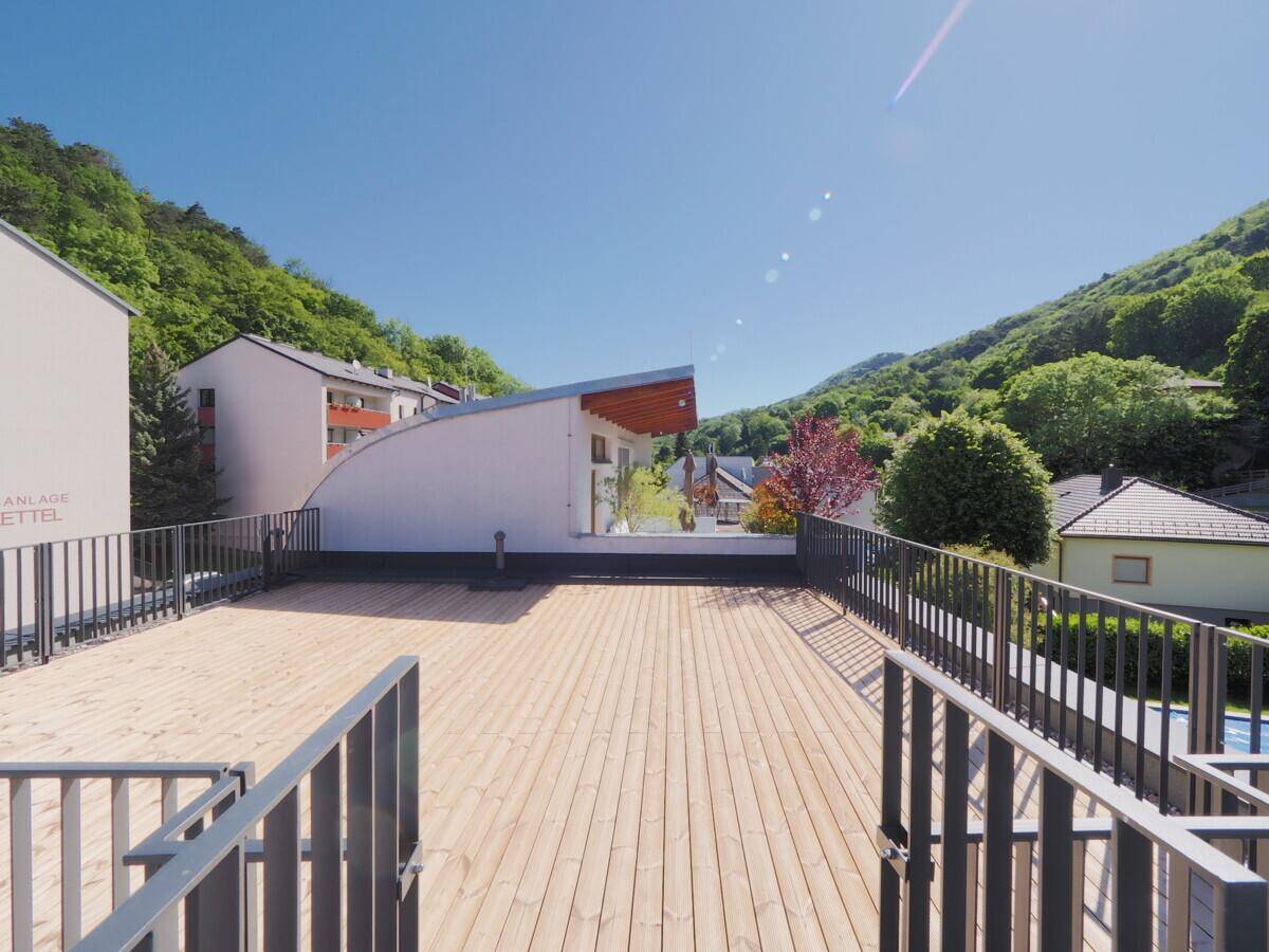 Große Dachterrasse mit Holzbelag und weitem Blick auf die umliegende Hügellandschaft.