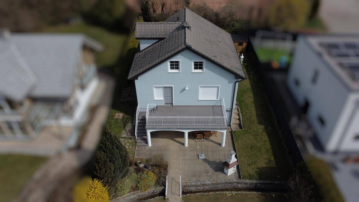 Vogelperspektive des Hauses mit Terrasse, Balkon und Gartenbereich.