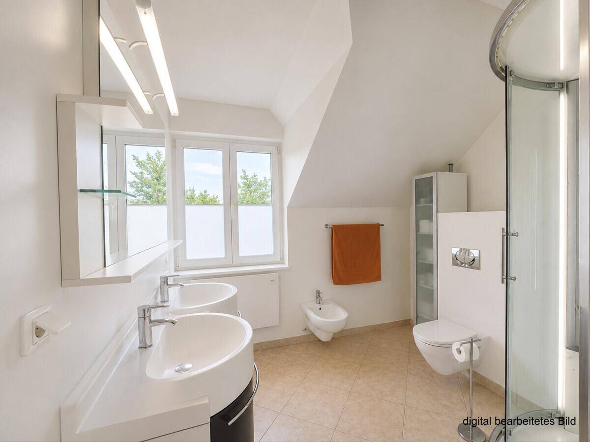 Modernes Badezimmer im Dachgeschoss mit Doppelwaschbecken, Dusche und Bidet.