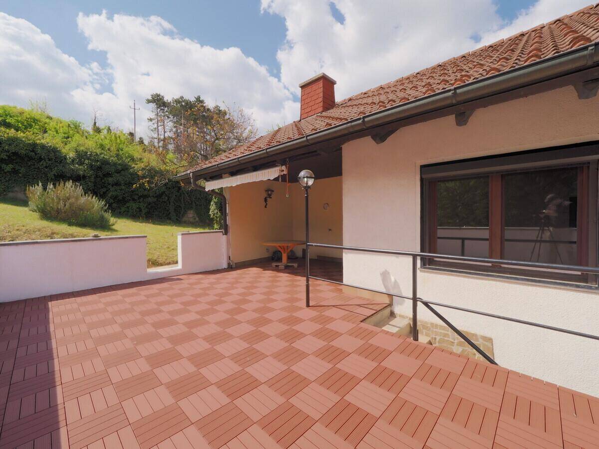 Große überdachte Terrasse mit Fliesenboden, ideal für entspannte Stunden im Freien.