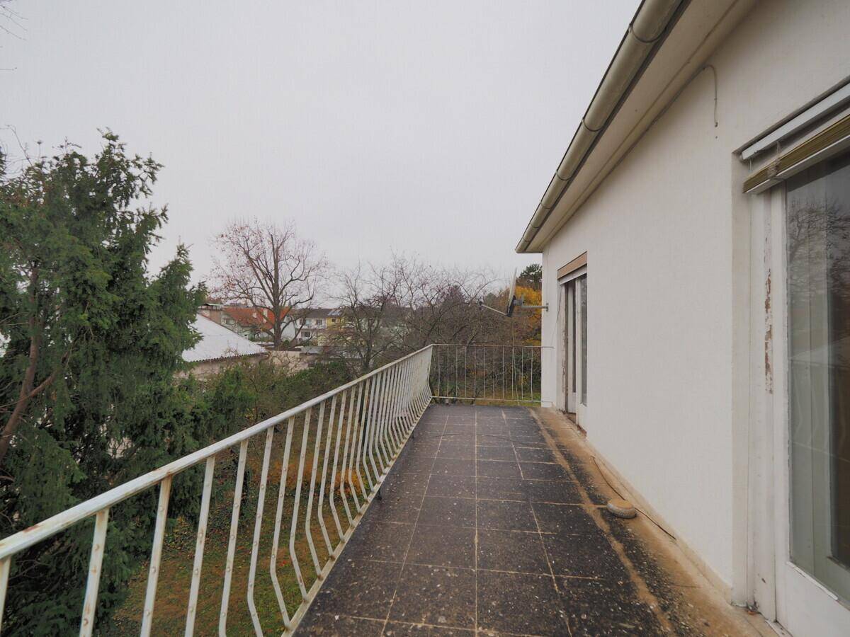Langer, schmaler Balkon mit Metallgeländer und Blick auf die Umgebung.