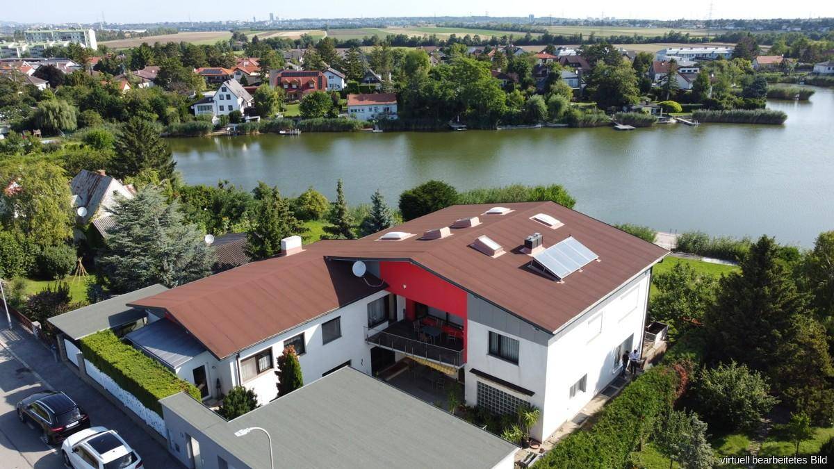 Luftaufnahme des modernen Hauses mit Satteldach, Balkon und Photovoltaikanlage.