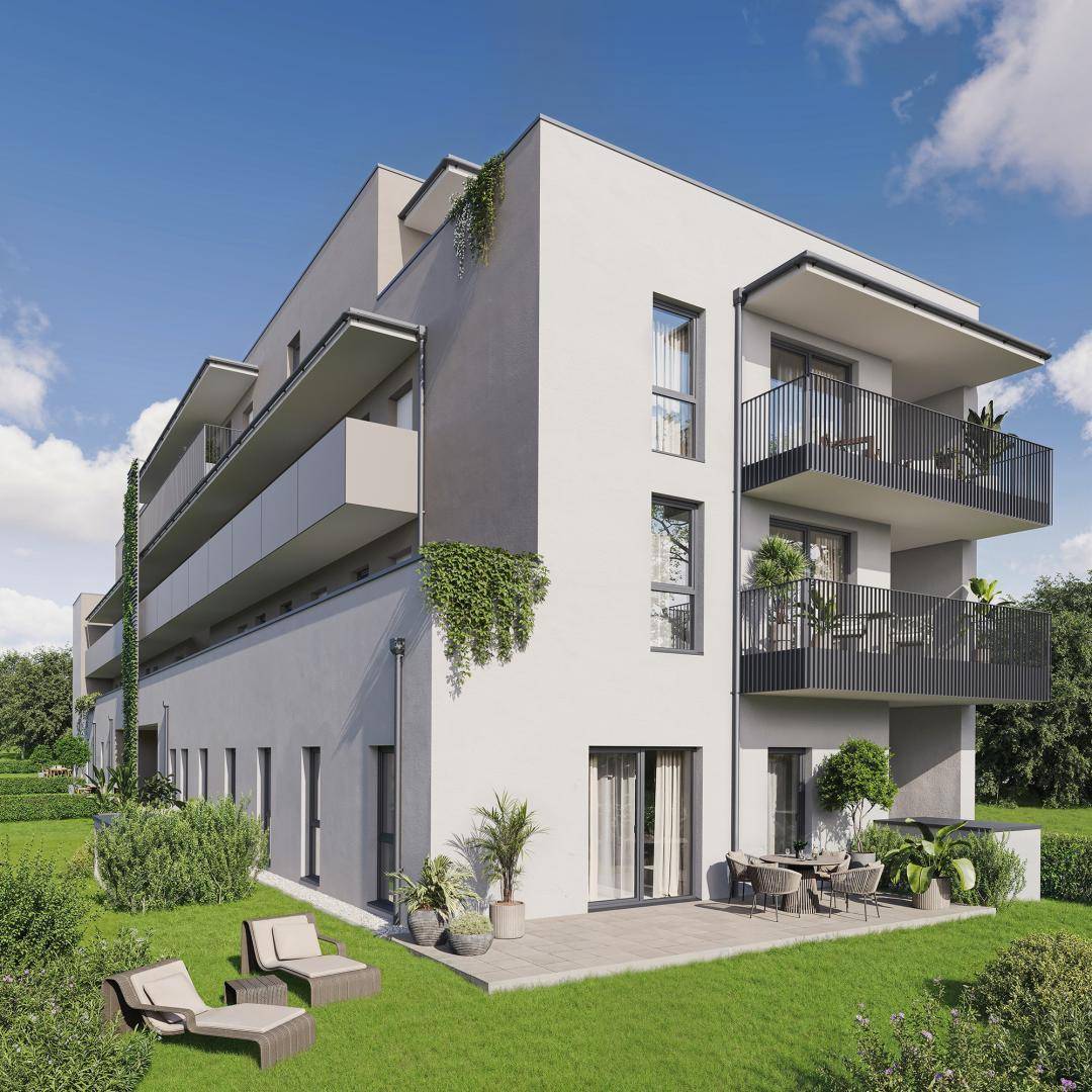 Moderne Wohnanlage mit Balkonen und einer Terrasse im Erdgeschoss, umgeben von Grünflächen.