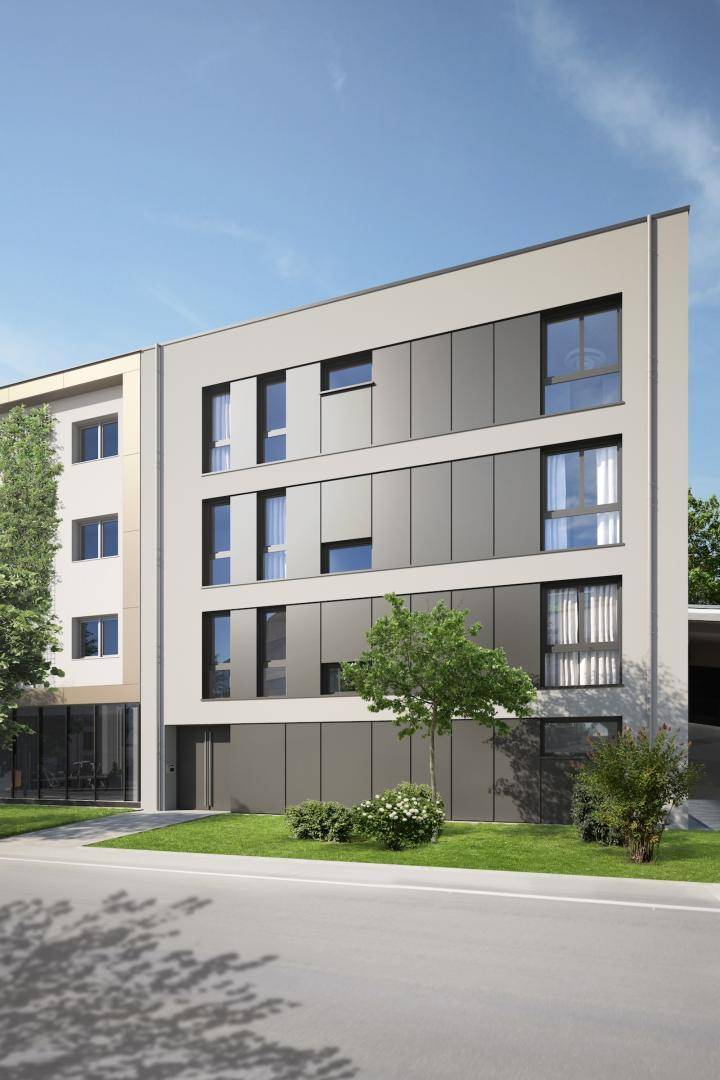 Zeitgenössisches Wohngebäude mit heller Fassade, großen Fenstern und gepflegten Grünflächen.