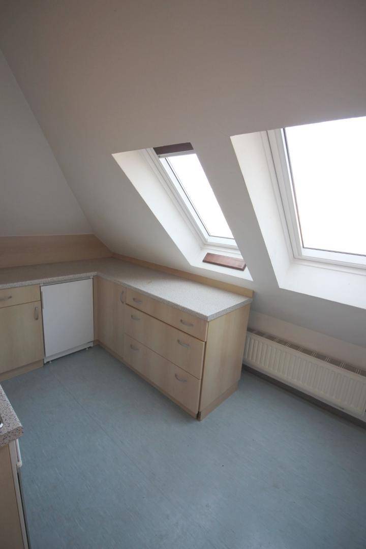 Kleine Küchenzeile im Dachgeschoss mit Dachfenstern und einfacher Ausstattung.
