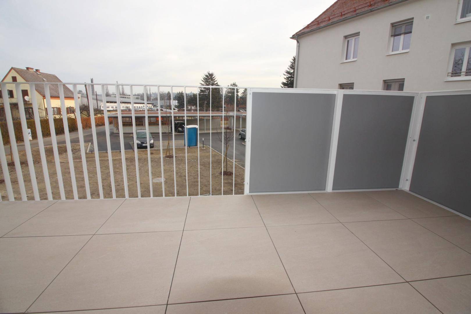 Geräumiger Balkon mit Fliesenboden und Blick auf die umliegende Wohngegend.
