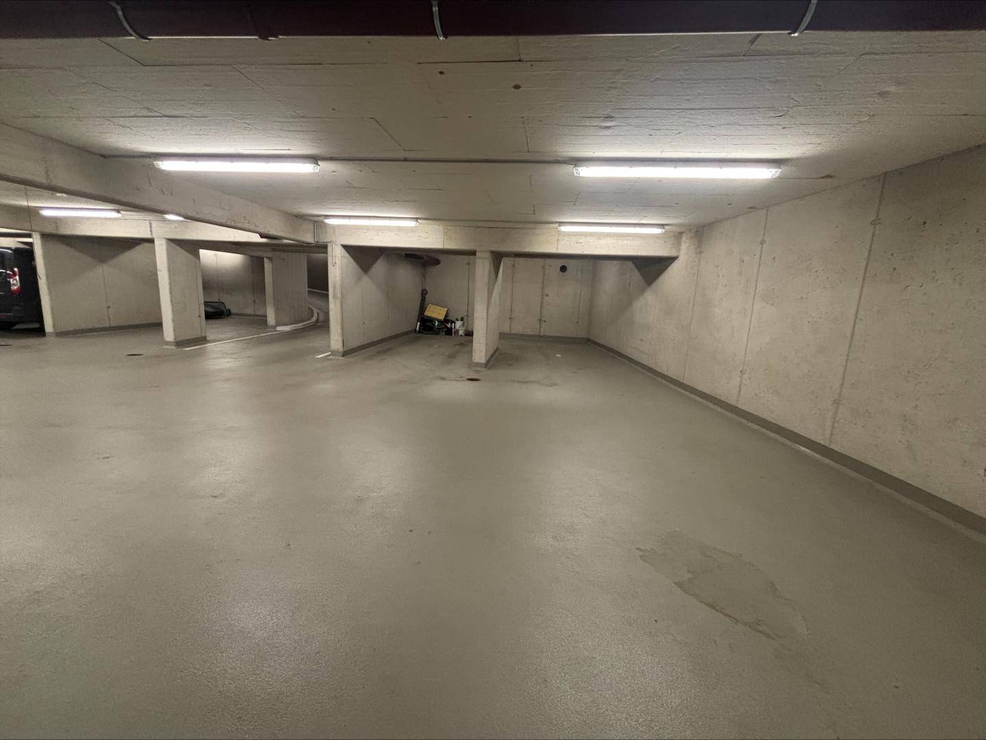 Geräumige Tiefgarage mit Betonstützen und ausreichend Platz für Fahrzeuge.