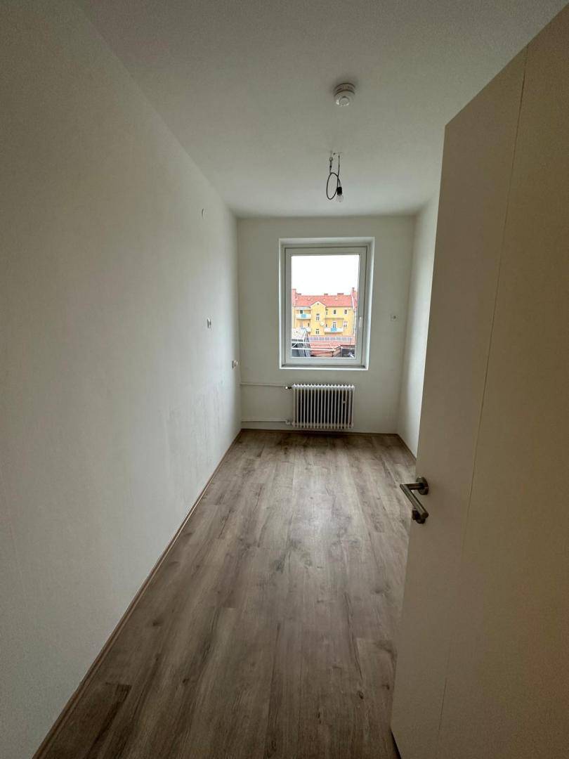Gemütliches Zimmer mit Laminatboden und einem Fenster, das für ausreichend Tageslicht sorgt.