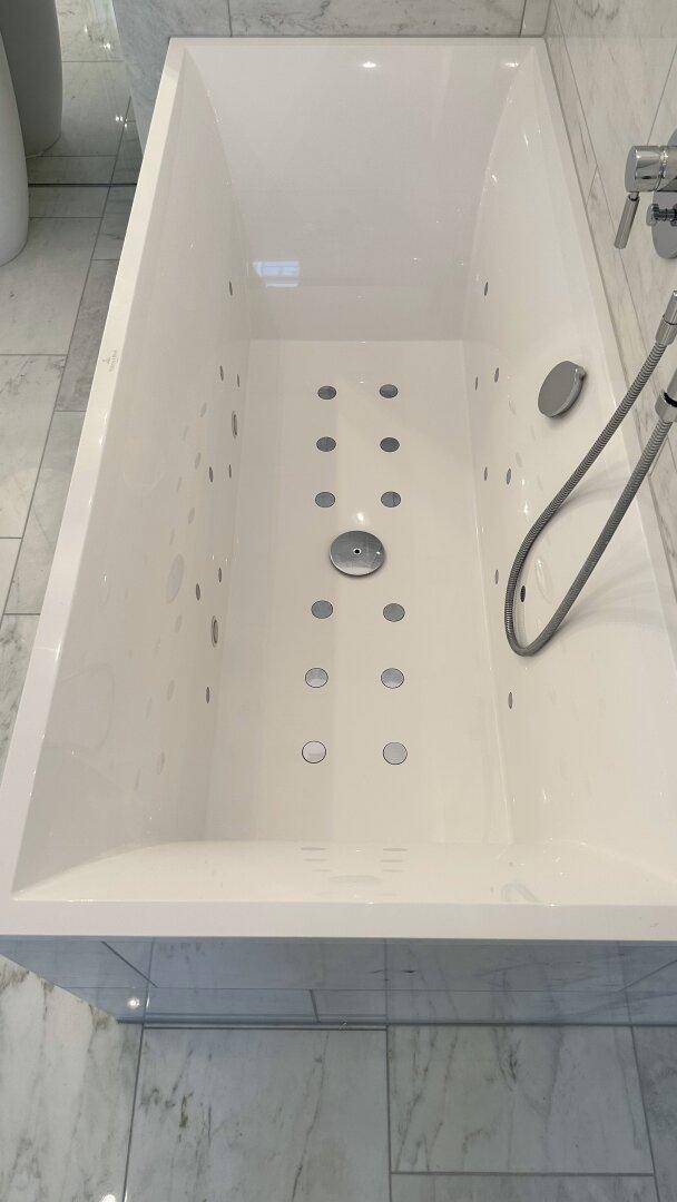 Detailaufnahme einer modernen Badewanne mit integrierten Düsen für ein Spa-Erlebnis.