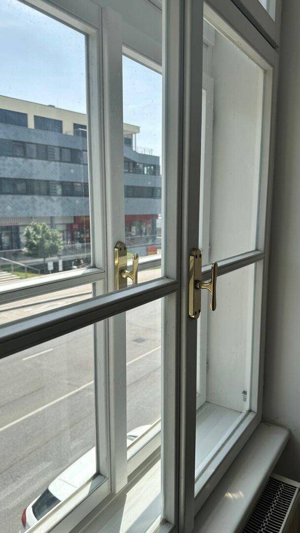 Nahaufnahme eines Fensters mit Blick auf die Straße und gegenüberliegende Gebäude.