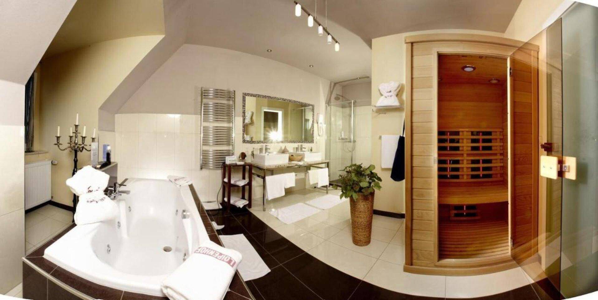 Großes Badezimmer mit Whirlpool-Badewanne, Sauna und modernem Doppelwaschbecken.