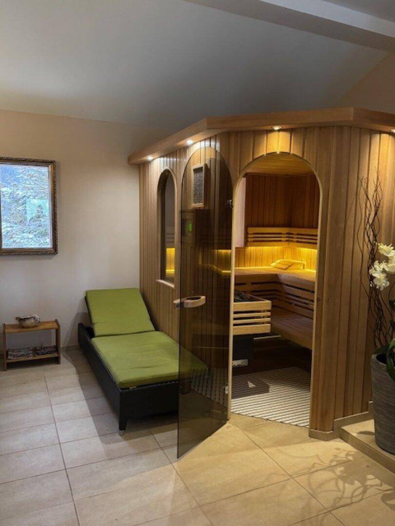 Moderne Holzsauna mit Glasfront und Liegefläche, bietet Entspannung nach einem aktiven Tag.