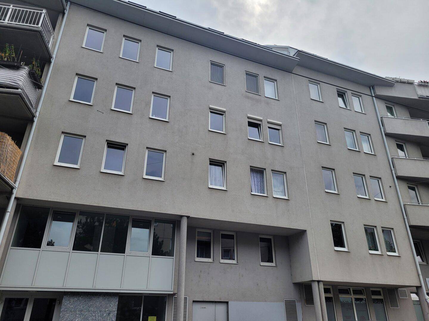 Mehrstöckiges Wohngebäude mit zahlreichen Fenstern und Balkonen an der Seite.