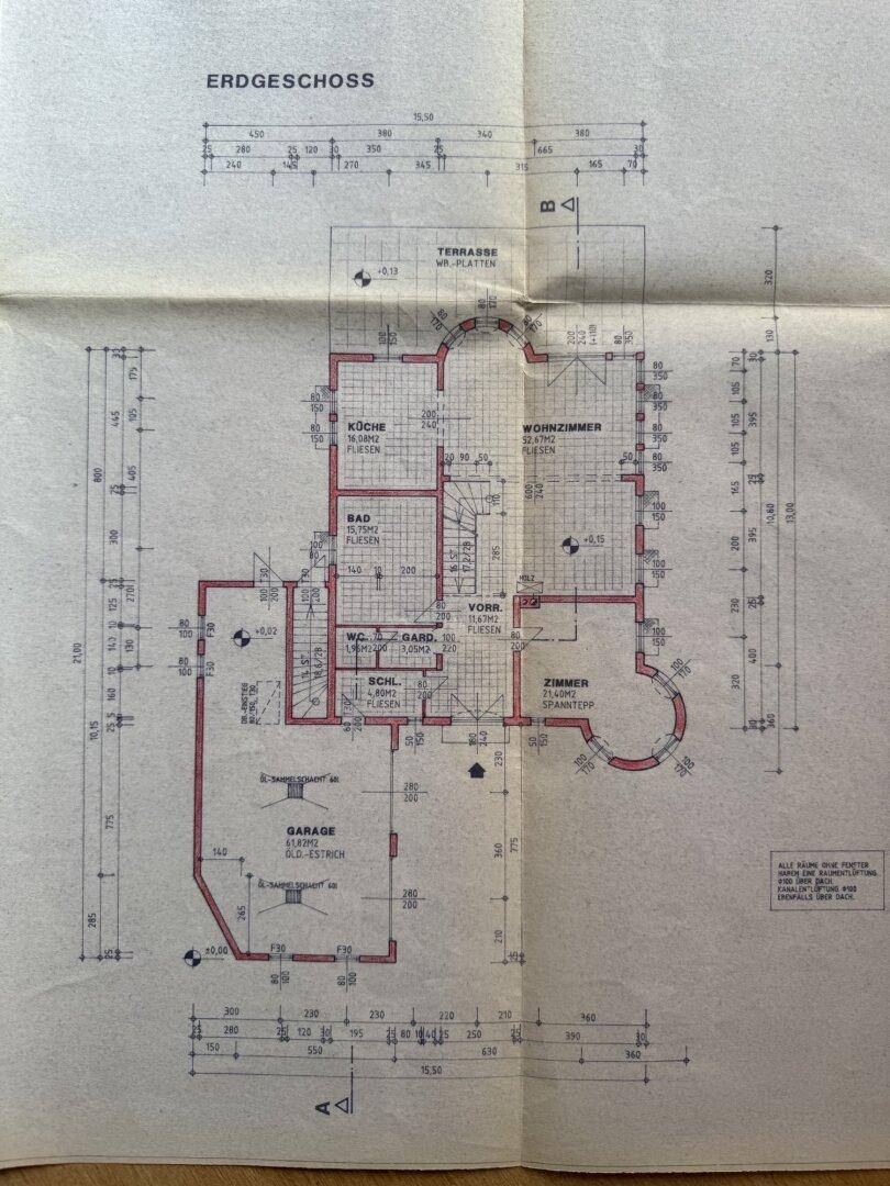 Grundriss des Erdgeschosses mit Küche, Wohnzimmer, Bad, WC, Garage und einer Terrasse.