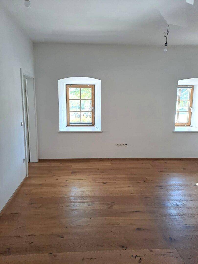 Geräumiges Zimmer mit hochwertigem Holzparkett und hellen Wänden, bereit für individuelle Gestaltung.