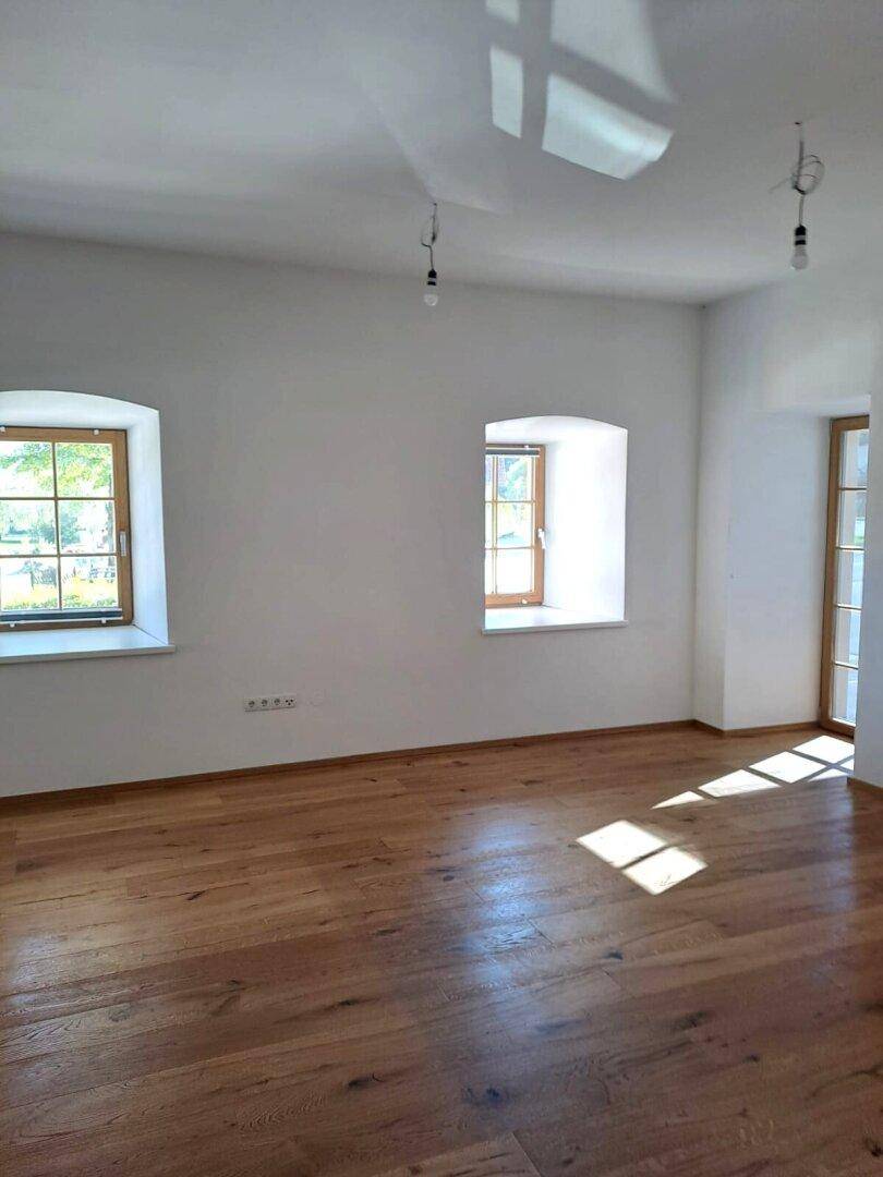 Helles Zimmer mit neuem Eichenparkettboden und weißen Wänden, ideal für Wohn- oder Schlafbereich.