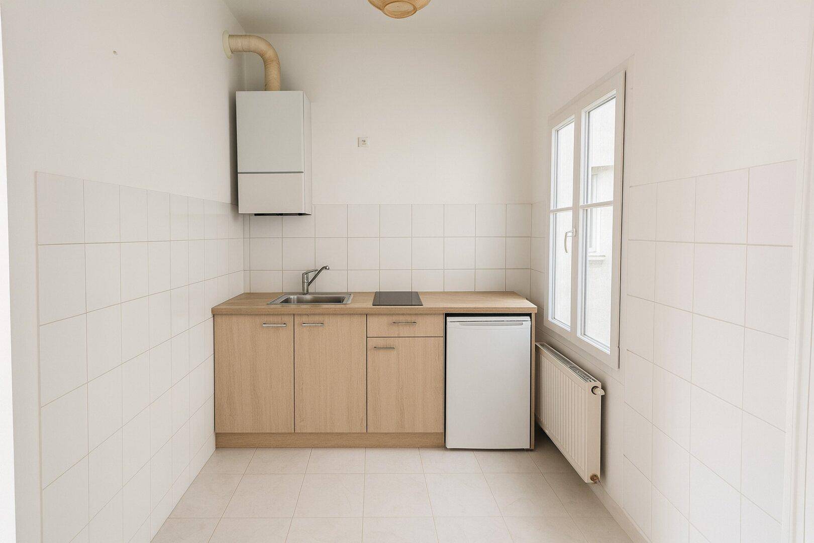 Kleine Küchenzeile mit Spüle, Kochfeld und Kühlschrank, ideal für kompaktes Wohnen.