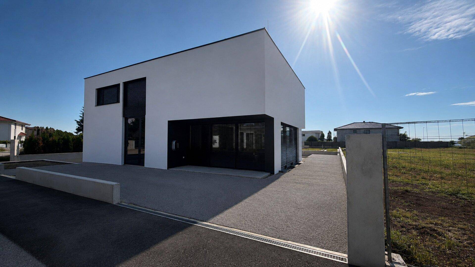 Zeitgenössisches Haus mit klarer Architektur, weißer Fassade und sonnigem Außenbereich.