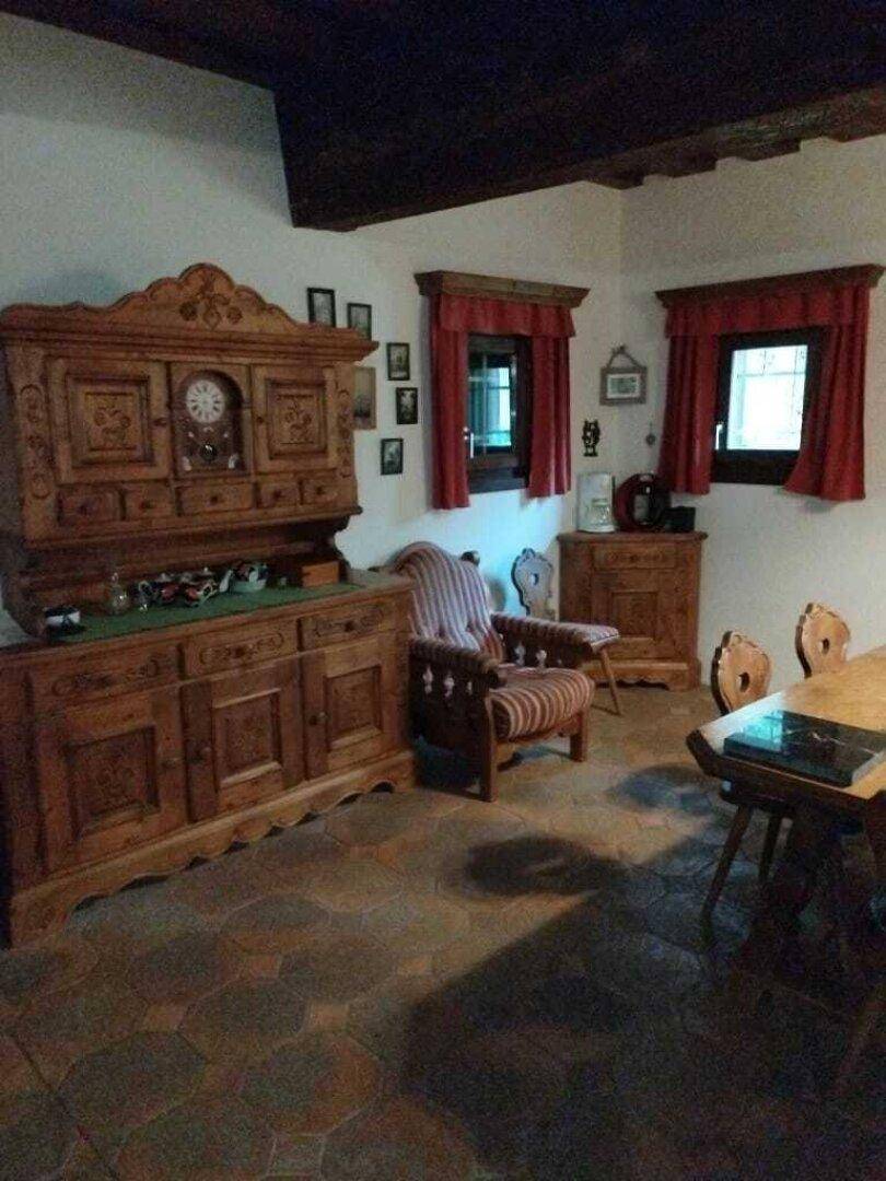 Rustikaler Essbereich mit großem Holzschrank, Holztisch und traditionellen Fliesenböden.