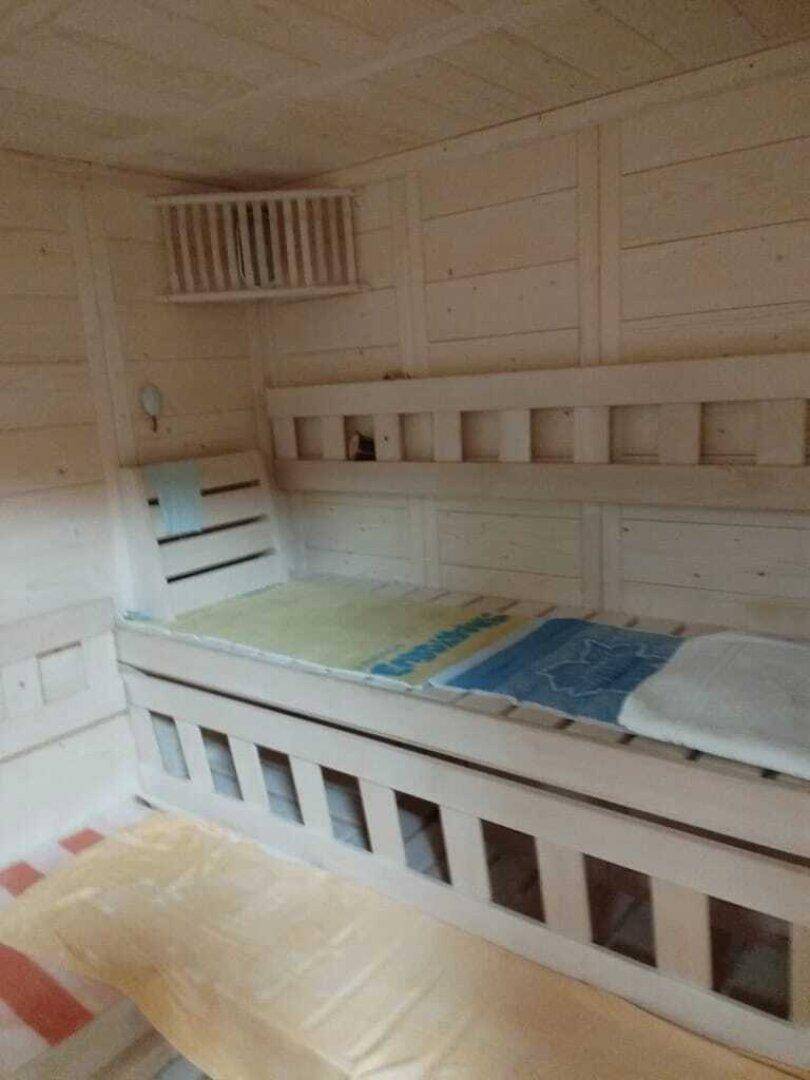 Innenansicht der Saunakabine mit Holzsitzen und Liegeflächen für mehrere Personen.