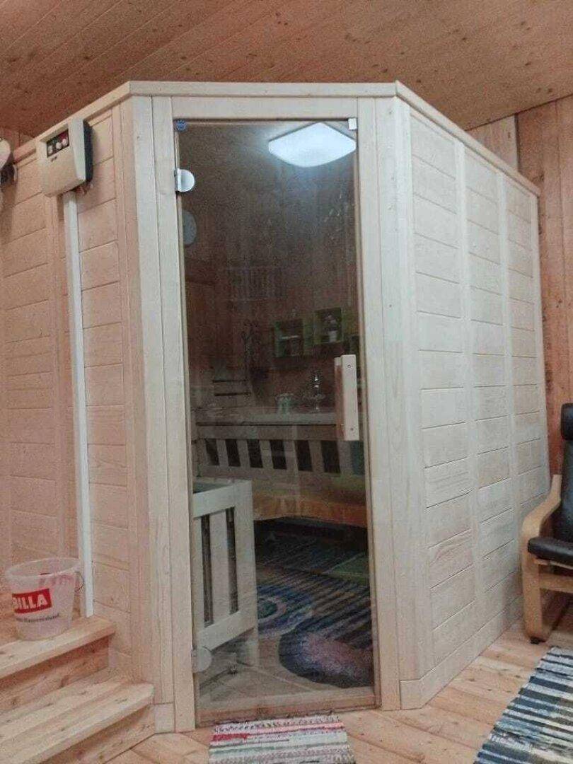 Moderne Saunakabine mit Glastür und Holzverkleidung, bereit zur Entspannung.