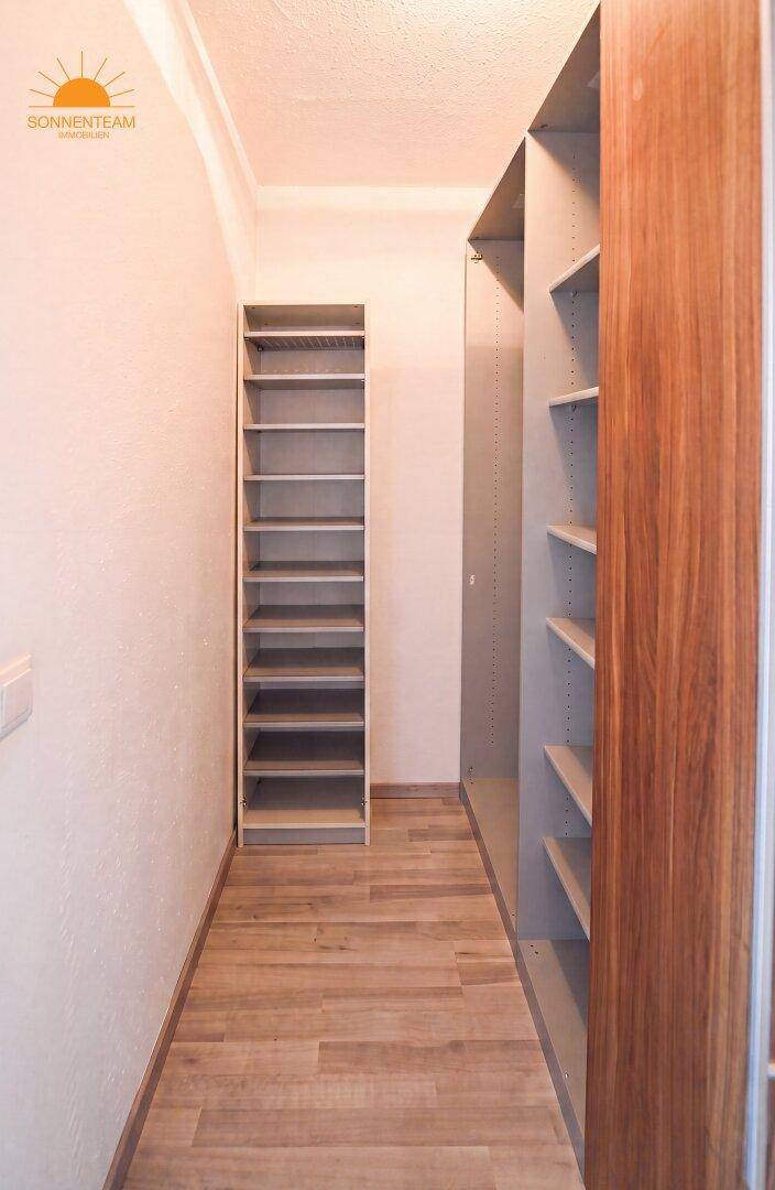 Praktischer begehbarer Kleiderschrank mit Regalsystemen für Kleidung und Schuhe.