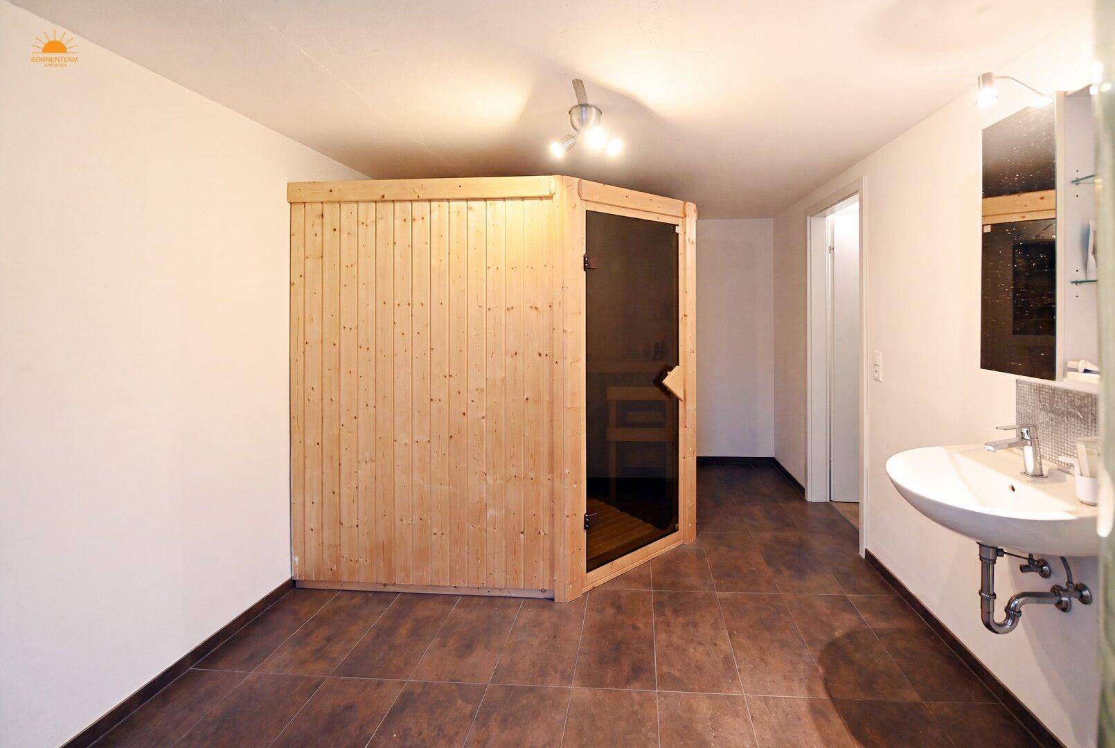 Badezimmer mit integrierter Sauna und Waschbecken, ideal für Entspannung.