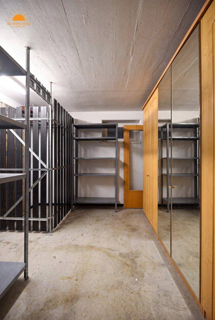 Geräumiger Kellerraum mit Regalen und einem großen Spiegelschrank für vielfältige Nutzung.
