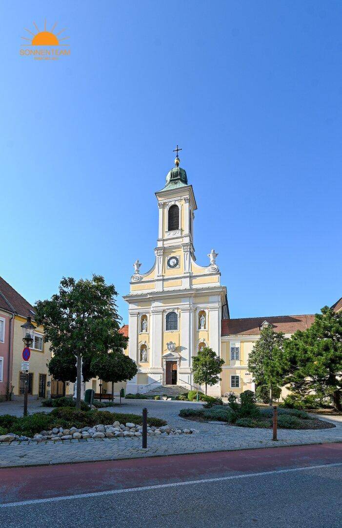 Historische Kirche mit Glockenturm und barocker Fassade im charmanten Stadtzentrum.