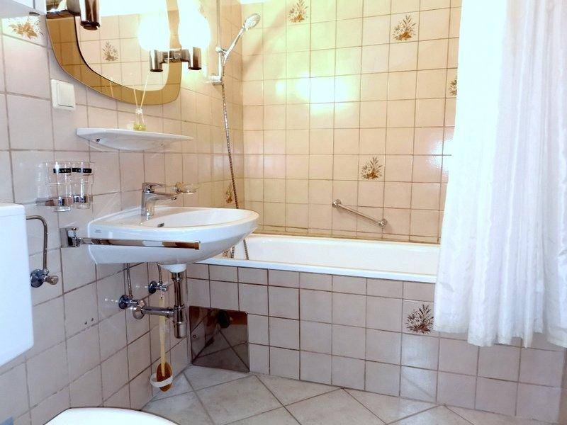 Badezimmer mit Badewanne und Waschmaschine