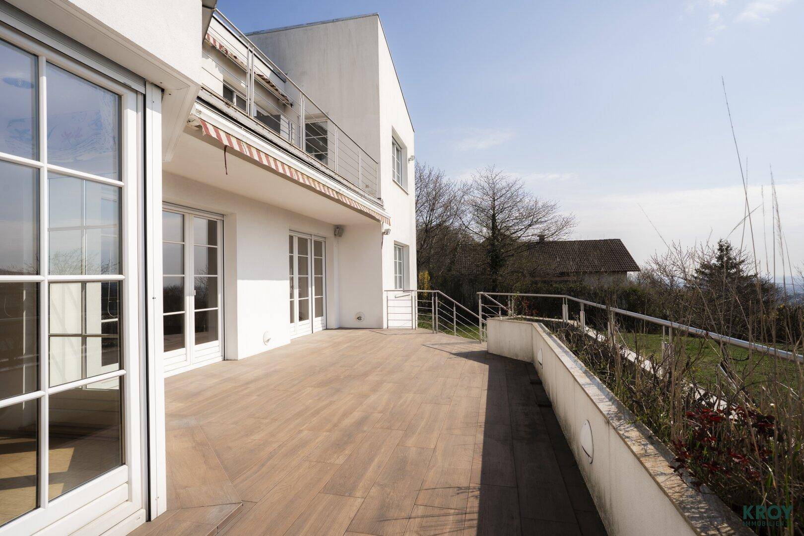 Große Holzterrasse mit Blick ins Grüne, ideal für Entspannung im Freien.