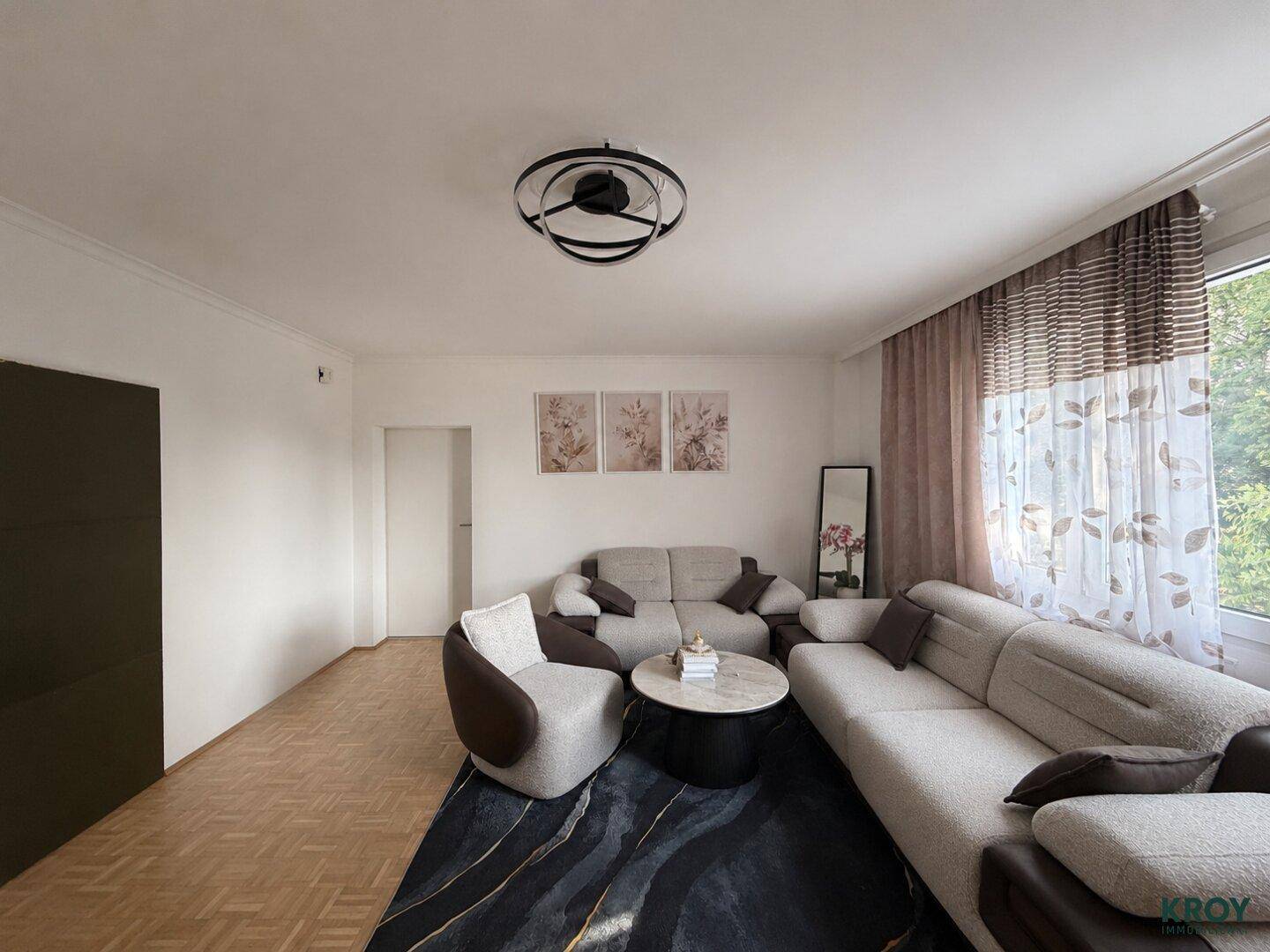 Geräumiges Wohnzimmer mit bequemen Sofas, Couchtisch und Parkettboden.